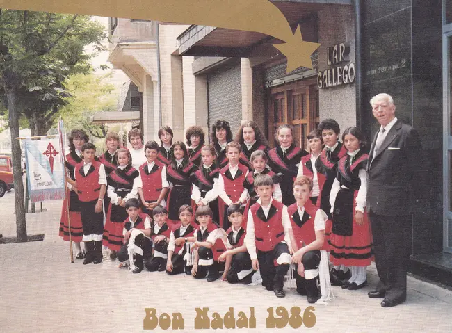 Grupo de niños vestidos de gallegos en la puerta del lar gallego.